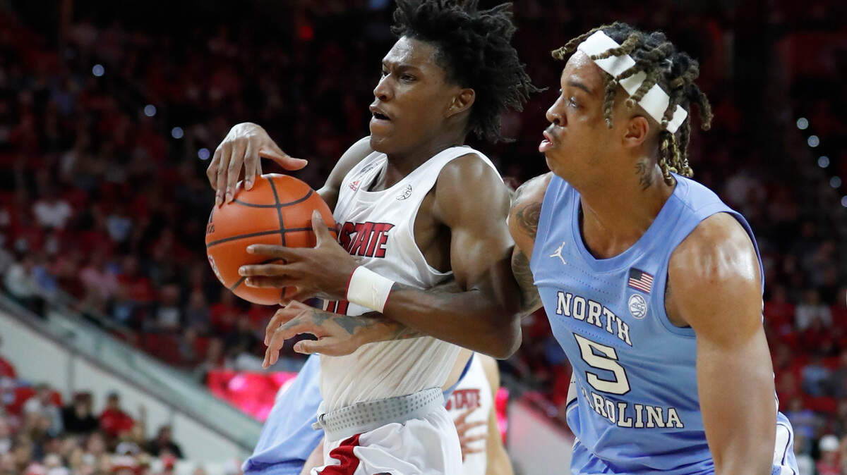 N.C. State’s Terquavion Smith (0) drives past North Carolina’s Armando Bacot (5) during the second half of UNC’s 84-74 victory over N.C. State at PNC Arena in Raleigh, N.C., Saturday, Feb. 26, 2022.