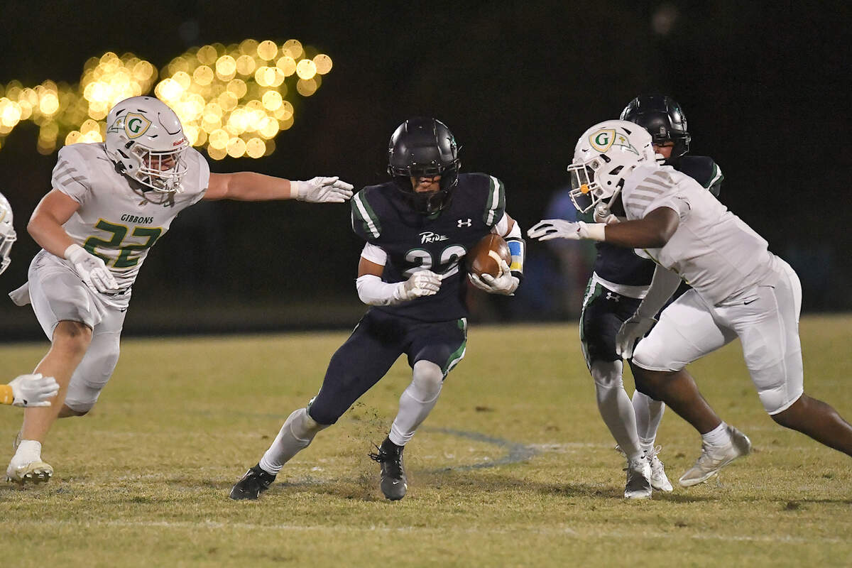 Leesville Road’s Jayden Lee Perry (22) runs for yardage against Cardinal Gibbons’ Christopher Shelton (22) and Corban McDaniel (1) during the first half. The Leesville Road Pride and the Cardinal Gibbons Crusaders met in a conference football game in Raleigh, N.C. on November 1, 2024.