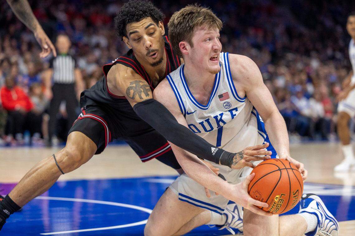 Duke’s Kon Knueppel (7) protects the ball from Louisville’s Terrence Edwards Jr. (5) in the first half on Saturday, March 15, 2025 during the ACC Tournament Championship at Spectrum Center in Charlotte, N.C.