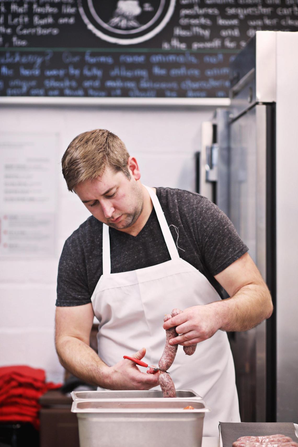 Butcher Drew Hannon, preps the meat Wednesday morning, January 16, 2019, at Left Bank Butchery located in the Blue Dogwood Public Market in Chapel Hill.