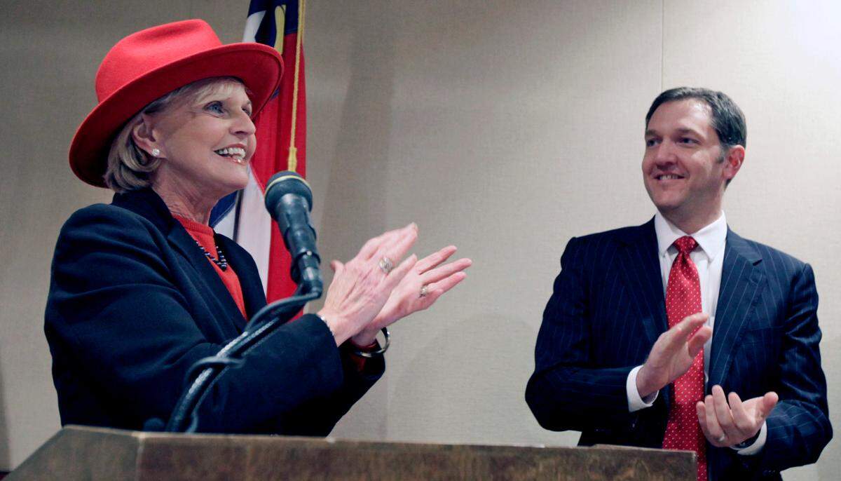 Gov. Bev Perdue applauds Red Hat CEO Jim Whitehurst, right, for his company’s decision to stay in Wake County in 2011.