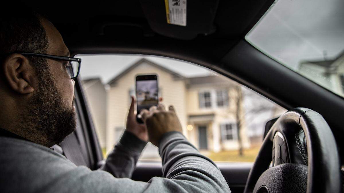Charlotte Realtor Jonathan Osman takes a photo of a house in a neighborhood where institutional investors have bought a large number of properties. These corporations then convert the homes into rentals.