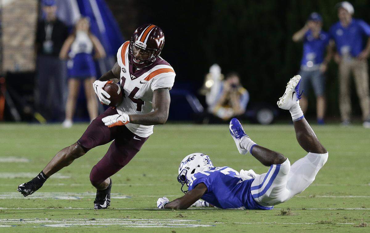 Virginia Tech’s Damon Hazelton (14) runs the ball while Duke’s Josh Blackwell dives during the first half of an NCAA college football game in Durham, N.C., Saturday, Sept. 29, 2018. 