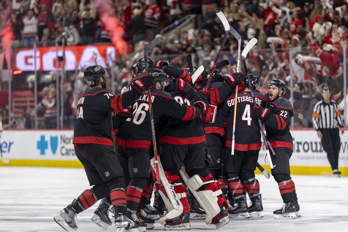 The Carolina Hurricanes celebrate at mid-ice after an overtime goal by Seth Jarvis (24) to secure a 4-3 victory over Vegas in Game 2 of the Stanley Cup Final, on Thursday, June 4, 2026 at Lenovo Center in Raleigh, N.C.