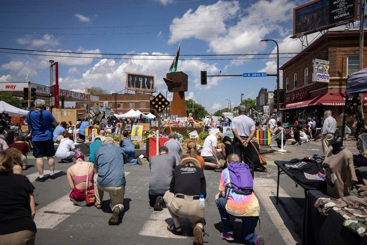 People take a knee during a moment of silence on the one year anniversary of George Floyd’s death on Tuesday, May 25, 2021, in Minneapolis.