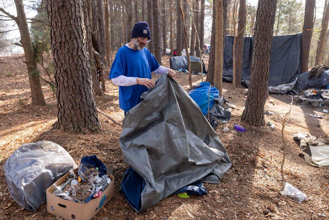 Kenneth Edwards packs up his tent, tarps and personal belongings in an encampment along Goode Street, adjacent to the State Farmers Market, on Friday, January 31, 2025 in Raleigh, N.C. Edwards said he had been living here since Halloween 2024. The property was recently posted, asking that the land be vacated by January 31, 2025.