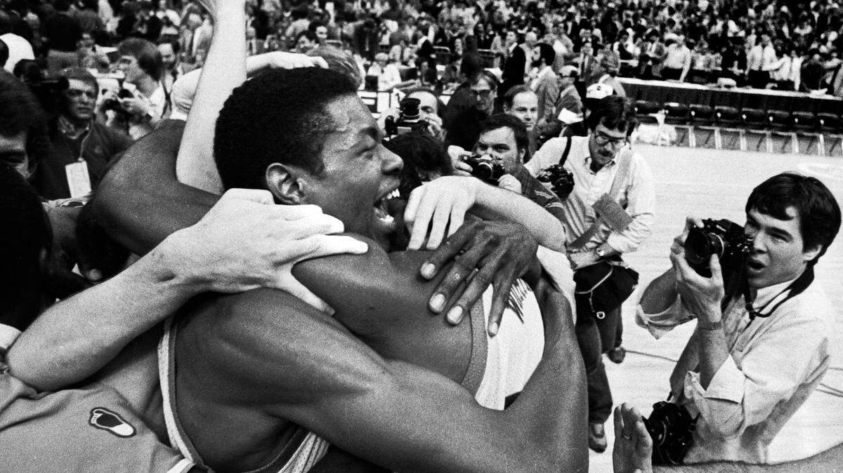 UNC center Sam Perkins celebrates with teammates on the floor of the Super Dome after the Tar Heels defeated Georgetown to win the 1982 National Championship.