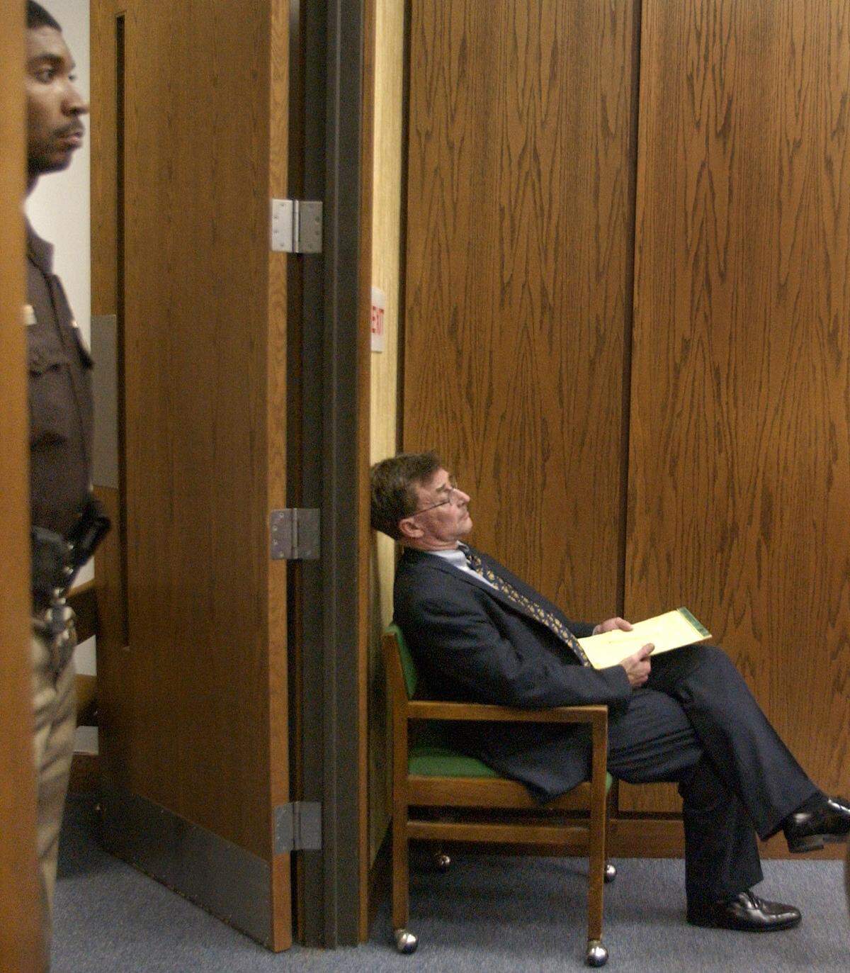 Michael Peterson sits in a chair at the back of the courtroom following proceedings, Wednesday, July 16, 2003.