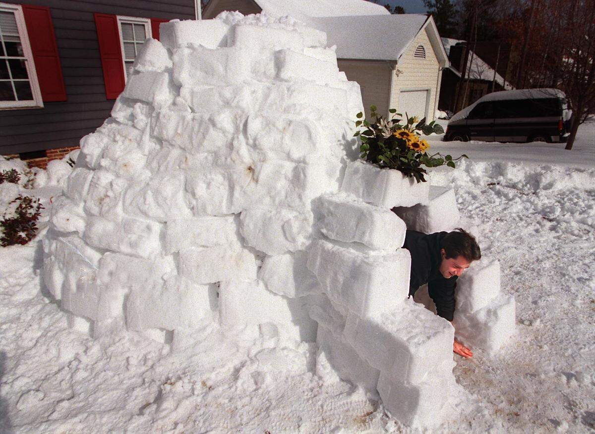 Mike Beaman climbs out of the igloo he built from blocks made by packing snow in the a recycling container after a 2000 storm that dumped almost two feet of snow in the Triangle