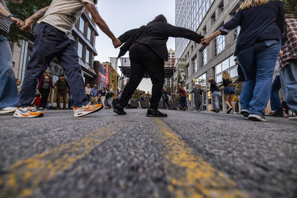 Festival-goers square dance on Martin Street during the Raleigh Wide Open music festival in downtown Raleigh on Friday, Oct. 3, 2025. The event features live bluegrass, folk, Americana and gospel artists.