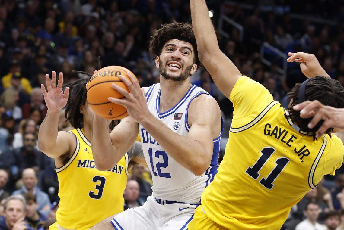 Duke’s Cameron Boozer (12) drives between Michigan's Roddy Gayle Jr. (11) and Elliot Cadeau (3) during the first half of Duke’s game against Michigan in the Capital Showcase at Capital One Arena in Washington, D.C., Saturday, Feb. 21, 2026.