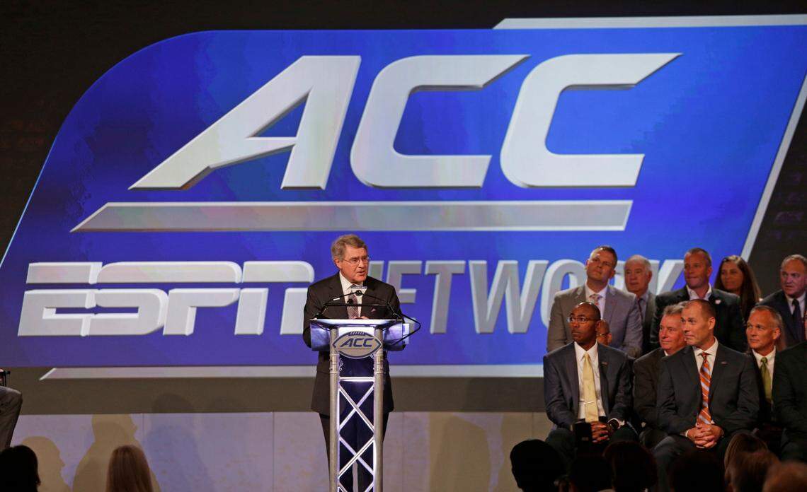 In this July 21, 2016, file photo, ACC Commissioner John Swofford, center, announces an ACC/ESPN Network during a news conference at the Atlantic Coast Conference Football Kickoff in Charlotte, N.C.
