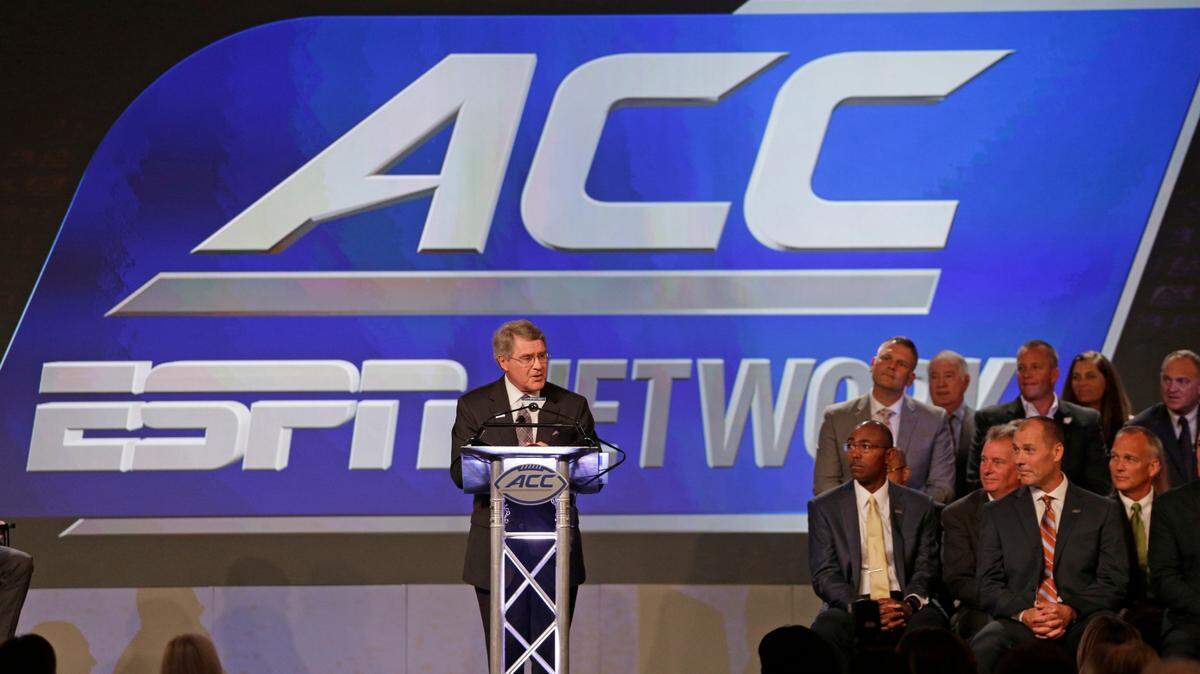 In this July 21, 2016, file photo, ACC Commissioner John Swofford, center, announces an ACC/ESPN Network during a news conference at the Atlantic Coast Conference Football Kickoff in Charlotte, N.C.