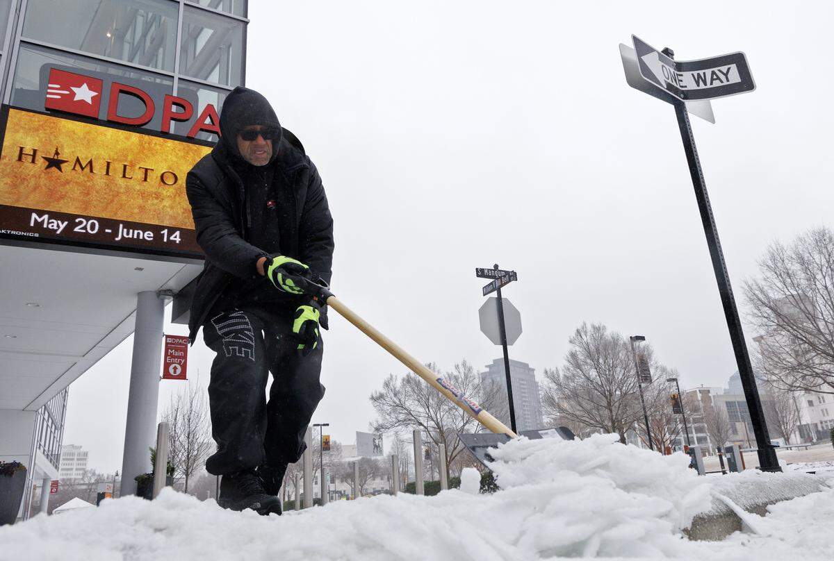 Rick Roberts clears snow and ice from a sidewalk along South Mangum Street in downtown Durham on Sunday, January 25, 2026.