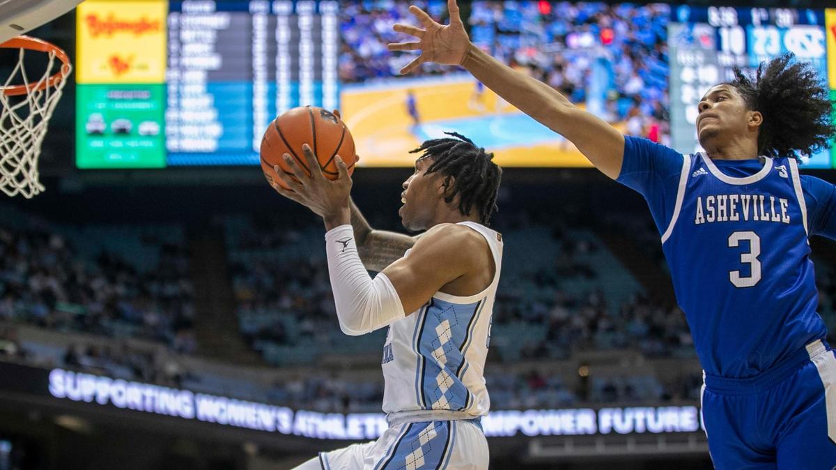 North Carolina’s Caleb Love (2) drives to the basket against UNC-Asheville’s Tajion Jones (3) during the first half on Tuesday, November 23, 2021 at the Smith Center in Chapel Hill, N.C.