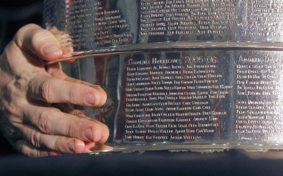 The names of the 2006 Canes team can be seen as a fan holds the Stanley Cup before  an NHL game played between the Carolina Hurricanes and the New York Islanders at the PNC Arena in Raleigh, N.C. on Feb. 13, 2016.   