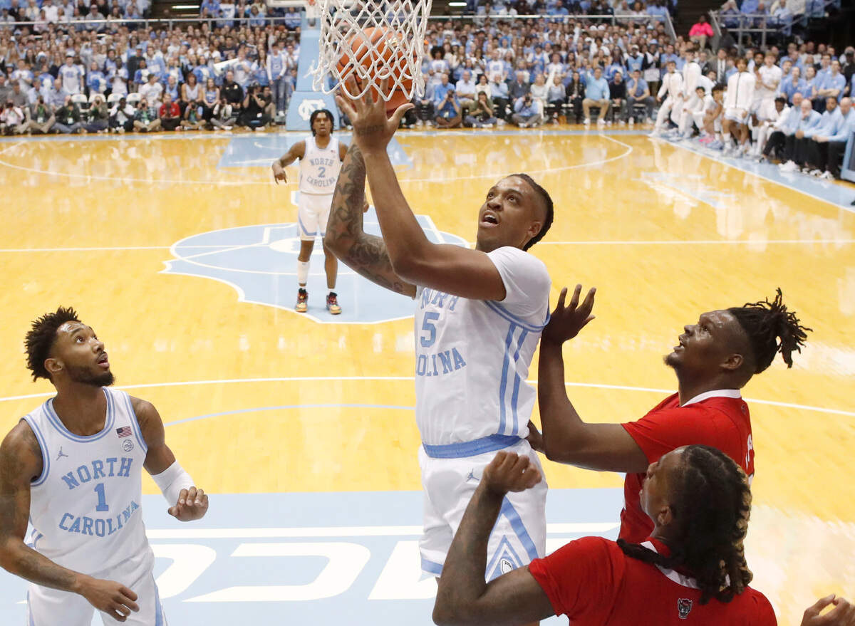 North Carolina’s Armando Bacot (5) shoots as N.C. State’s D.J. Burns Jr. (30) defends during UNC’s 80-69 victory over N.C. State at the Smith Center in Chapel Hill, N.C., Saturday, Jan. 21, 2023.