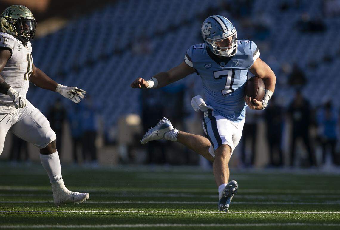 North Carolina quarterback Sam Howell (7) scores the game winning touchdown on a 20-yard carry ahead of Wake Forest’s Miles Fox (11) late in the fourth quarter to give the Tar Heels’ a 52-45 lead.