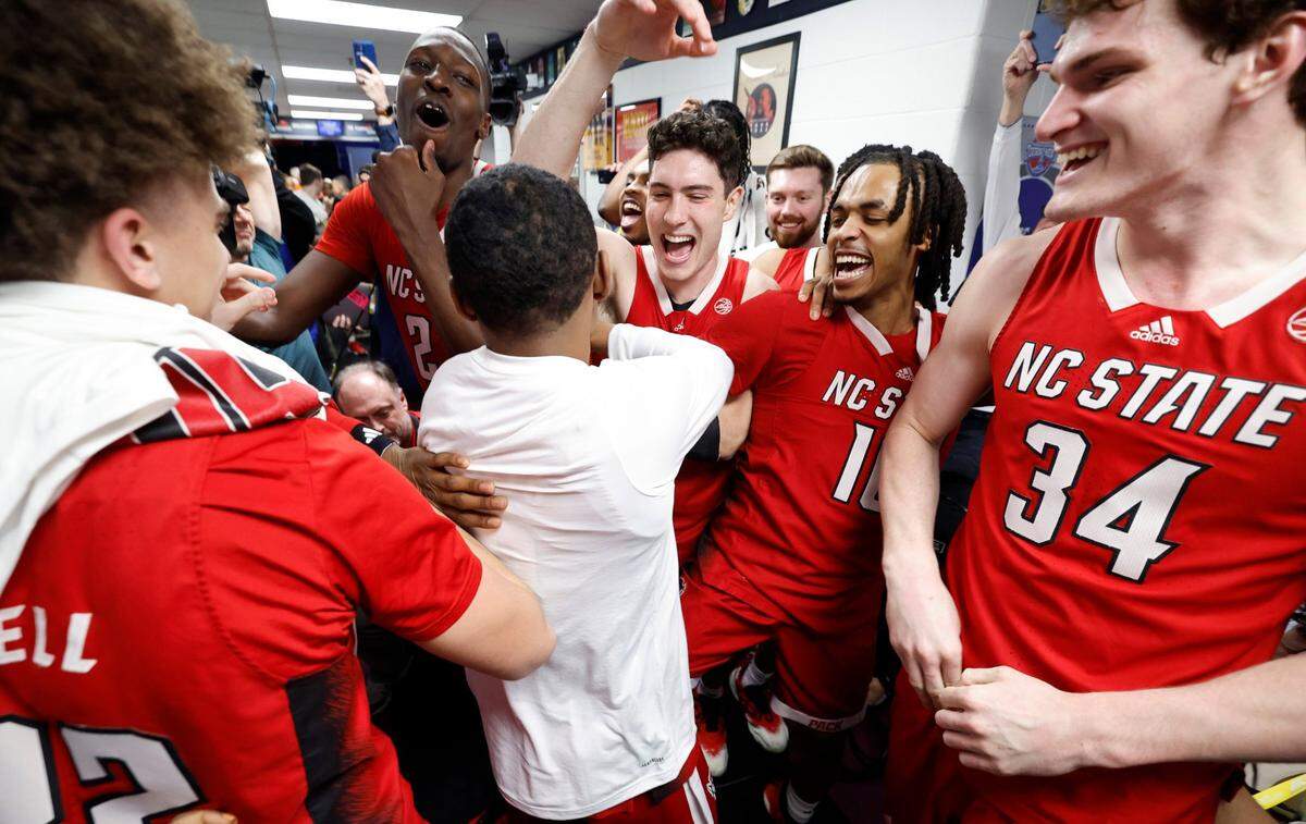 The Wolfpack team celebrates with KJ Keatts, center, after he placed N.C. State’s sticker on the board after N.C. State’s 83-65 victory over Syracuse in the second round of the 2024 ACC Men’s Basketball Tournament at Capital One Arena in Washington, D.C., Wednesday, March 13, 2024.