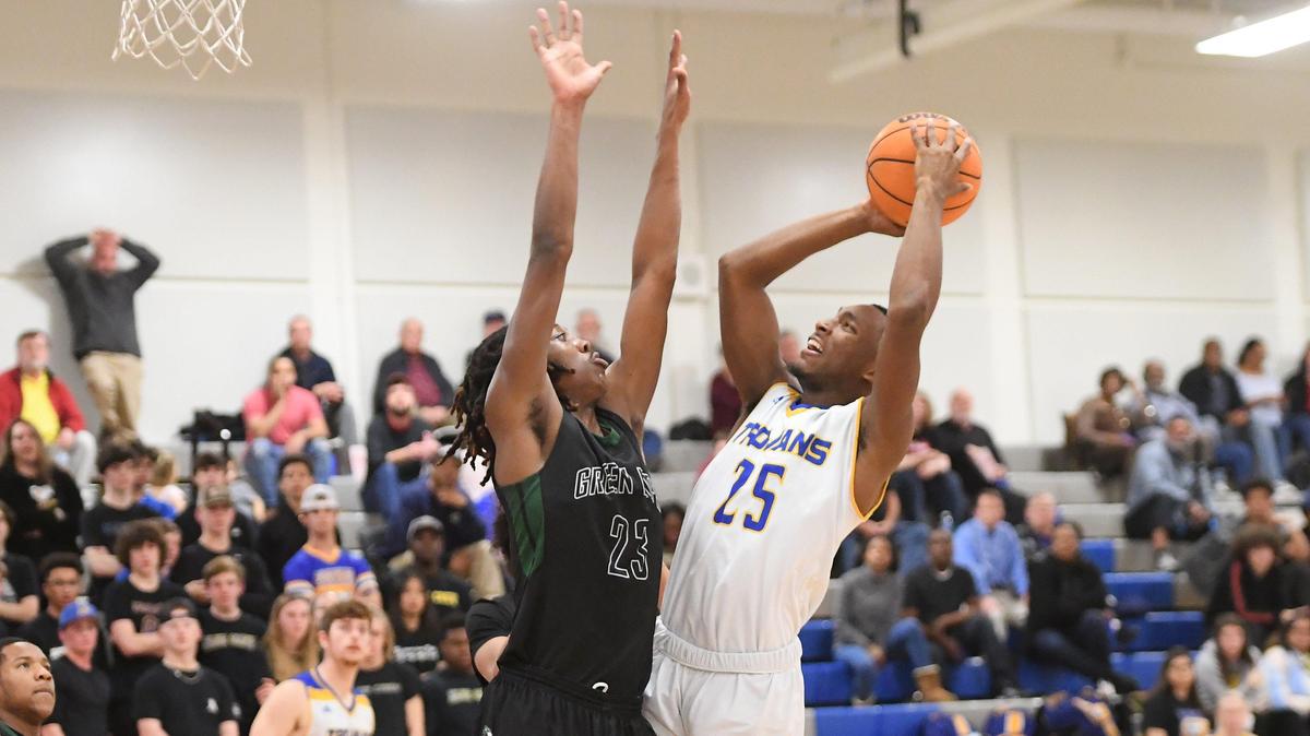 Sean Bennett (25) of Garner scores a two point basket against Tre Morgan (23) of Green Hope. The Green Hope Falcons visited the Garner Trojans in a high school boys basketball game on February 27, 2020.