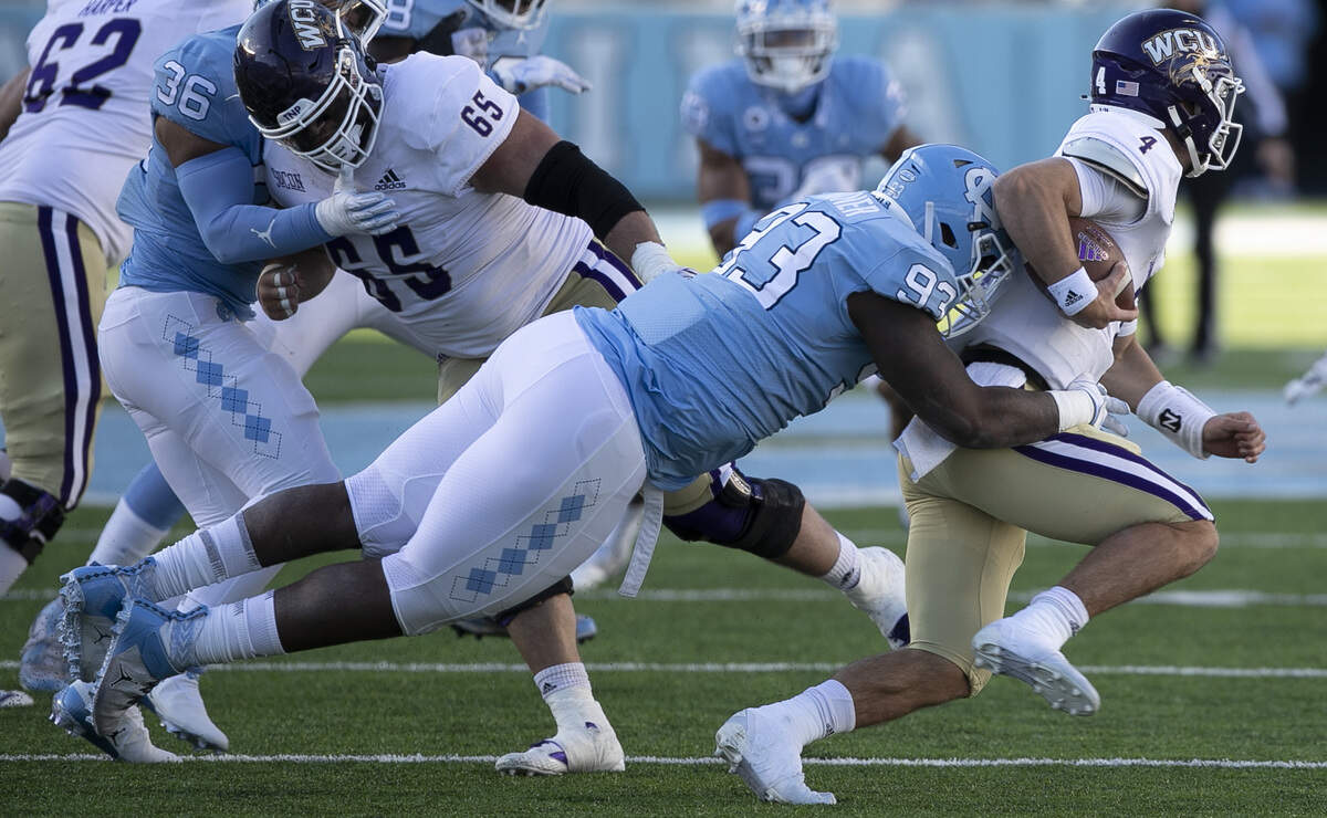 Western Carolina quarterback Kason Lincke (4) is stopped for a loss of five yards by North Carolina’s Kristian Varner (93) in the fourth quarter on Saturday, December 5, 2020 at Kenan Stadium in Chapel Hill, N.