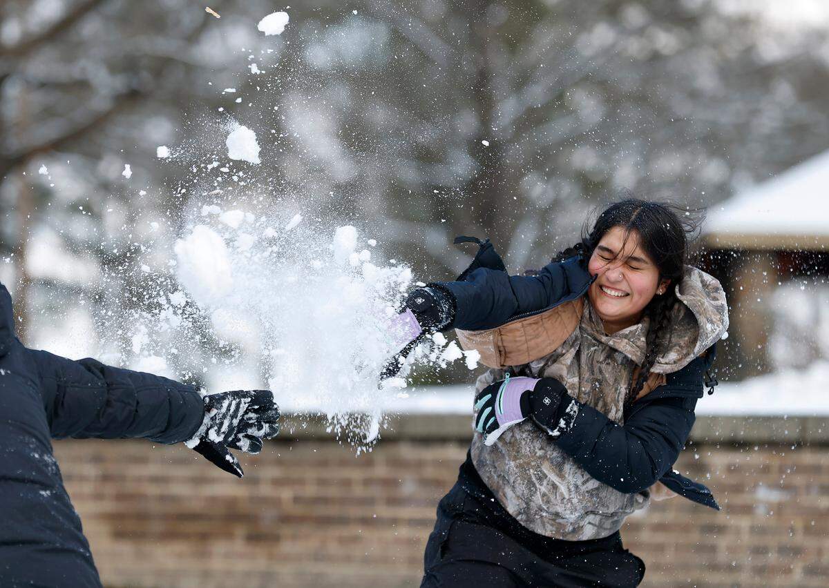 Melany Hernandez throws a snowball at her mother, Janet Ochoa, at Duke Park on Thursday, Feb. 20, 2025, in Durham, N.C.