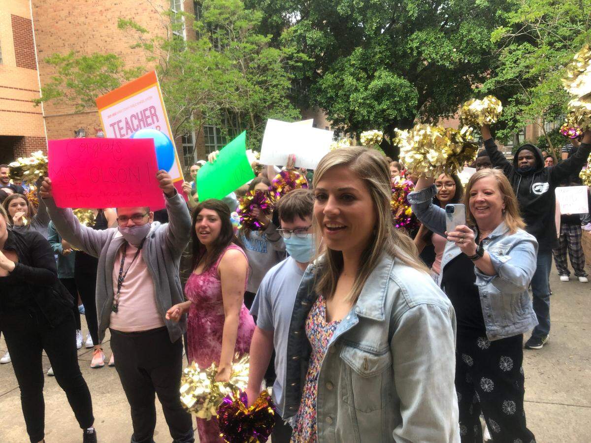 Caroline Olson holds a bouquet of flowers as she’s honored at a ceremony at Broughton High School in Raleigh, N.C., on May 12, 2022 after she was named Wake County’s 2022-23 Teacher of the Year.
