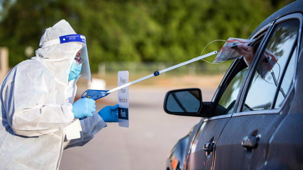 Onyx Flowers, a pharmacy associate with Walmart, safely gives a pre-registered individual a COVID-19 test to be self administered in their car with their window up at the Ramsey Street Walmart parking lot in Fayetteville, N.C. on Friday, May 15, 2020. The tests, which will be processed by eTrueNorth, are now available to people who qualify and pre-register from 7a.m. to 9a.m. on Mondays, Wednesdays and Fridays.