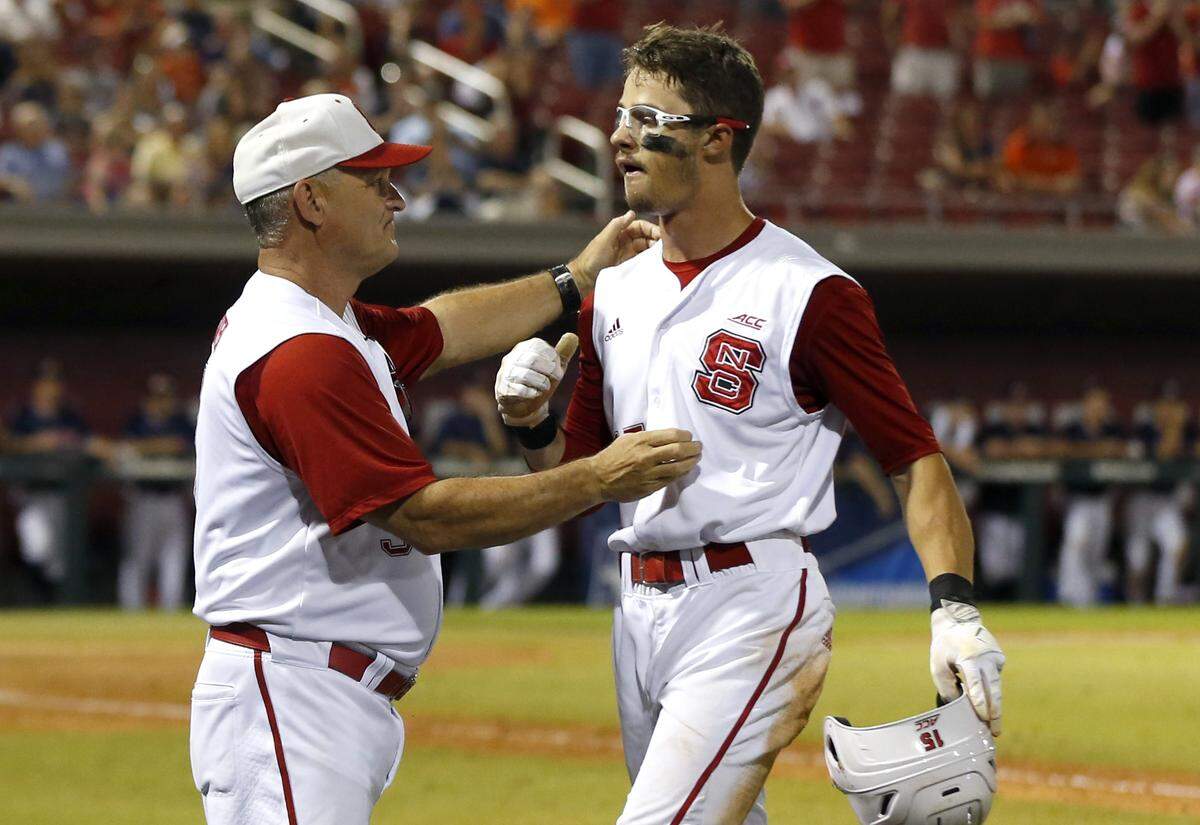 N.C. State's Elliott Avent hugs Josh McLain (15) as he comes off the field in the ninth inning during Auburn's 15-7 victory over N.C. State in the Raleigh Regional at Doak Field in Raleigh, N.C., Sunday, June 3, 2018.