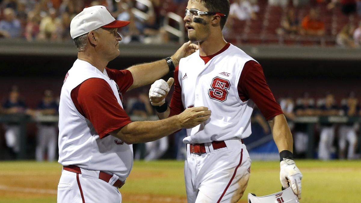 N.C. State’s Elliott Avent hugs Josh McLain (15) as he comes off the field in the ninth inning during Auburn’s 15-7 victory over N.C. State in the Raleigh Regional at Doak Field in Raleigh, N.C., Sunday, June 3, 2018.
