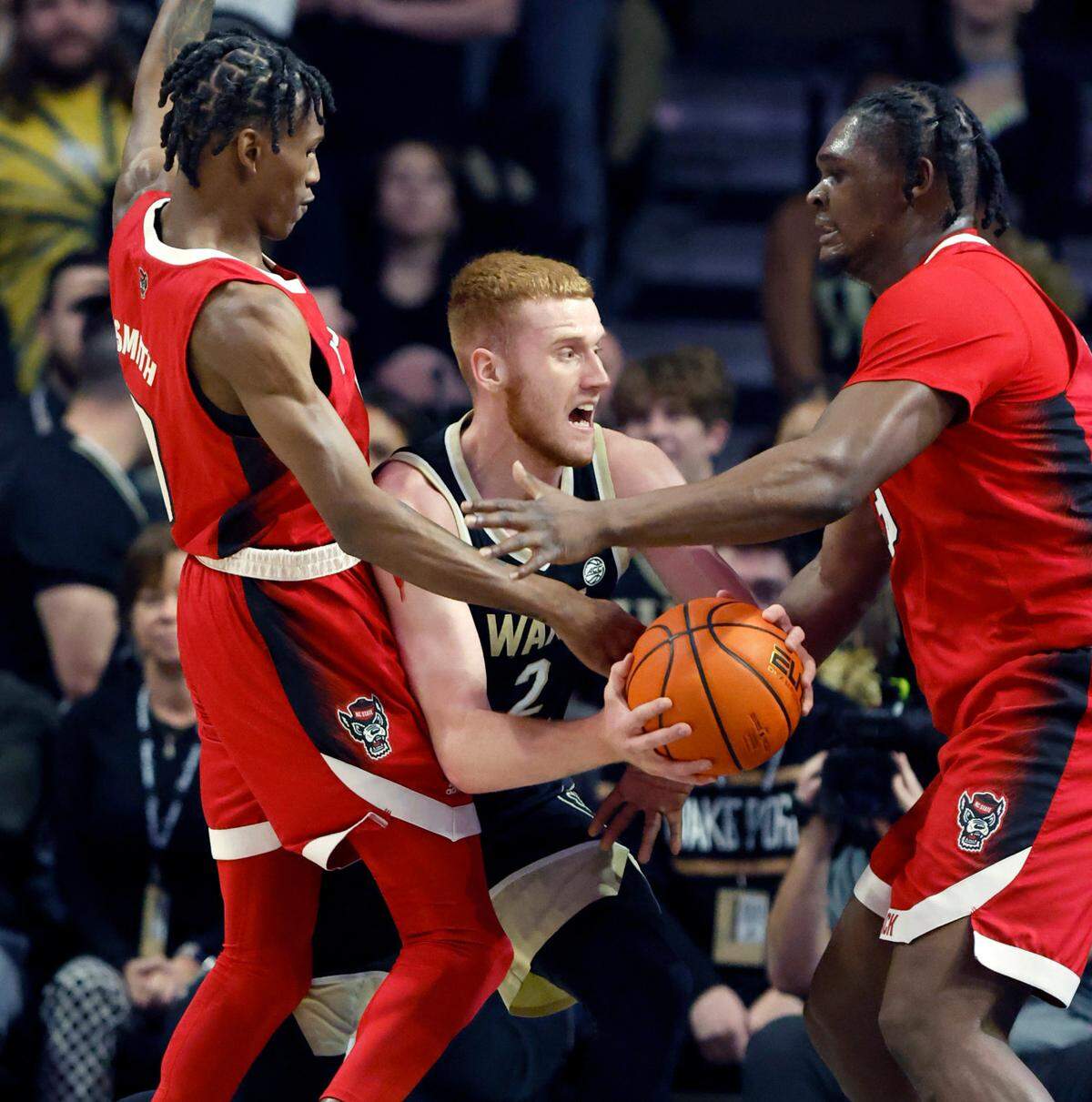 N.C. State’s Terquavion Smith (0) and D.J. Burns Jr. (30) defend Wake Forest’s Cameron Hildreth (2) during the first half of N.C. State’s game against Wake Forest at Joel Coliseum in Winston-Salem, N.C., Saturday, Jan. 28, 2023.