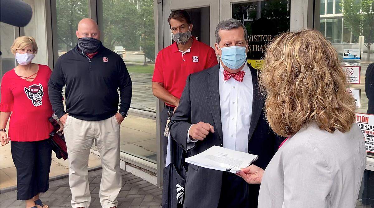 John Ruocchio, father of Thomas Ruocchio, along with other N.C. State football parents, delivers a petition to Noelle Talley, right, with the Governor’s Office Thursday, Sept. 17, 2020. The petition, signed by parents of 96 players, asks that they be allowed to attend the Wolfpack’s home opener Sept. 19.