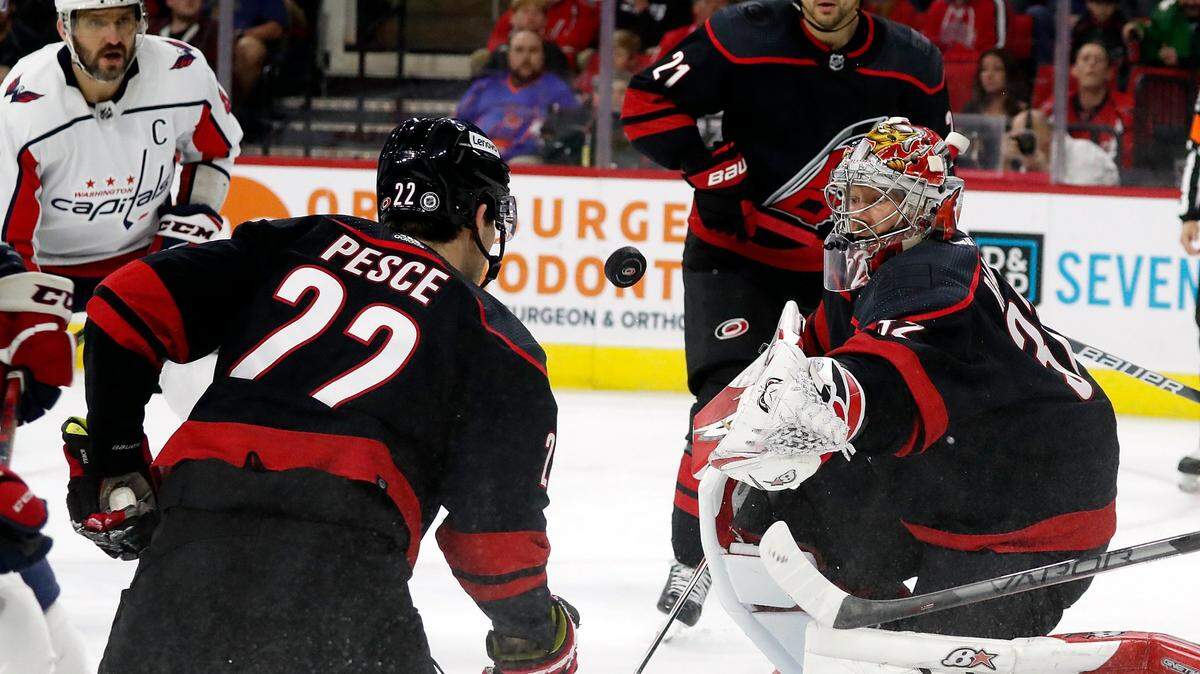 Carolina Hurricanes goaltender Antti Raanta (32) blocks a shot in front of teammates Brett Pesce (22) and Nino Niederreiter (21) with Washington Capitals’ Alex Ovechkin (8) nearby during the first period of an NHL hockey game in Raleigh, N.C., Friday, March 18, 2022. (AP Photo/Karl B DeBlaker)