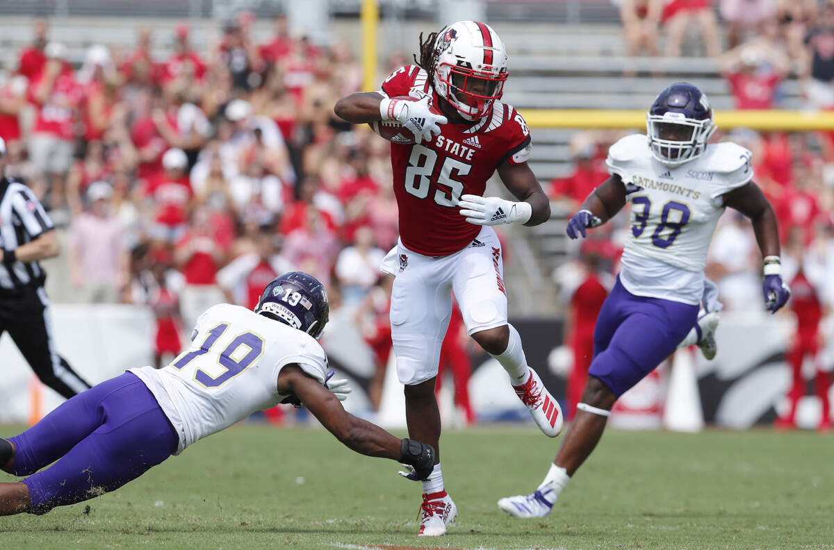 N.C. State wide receiver Keyon Lesane (85) avoids the tackle by Western Carolina defensive back Devarius Cortner (19) during the first half of N.C. State’s game against Western Carolina at Carter-Finley Stadium in Raleigh, N.C., Saturday, Sept. 7, 2019.