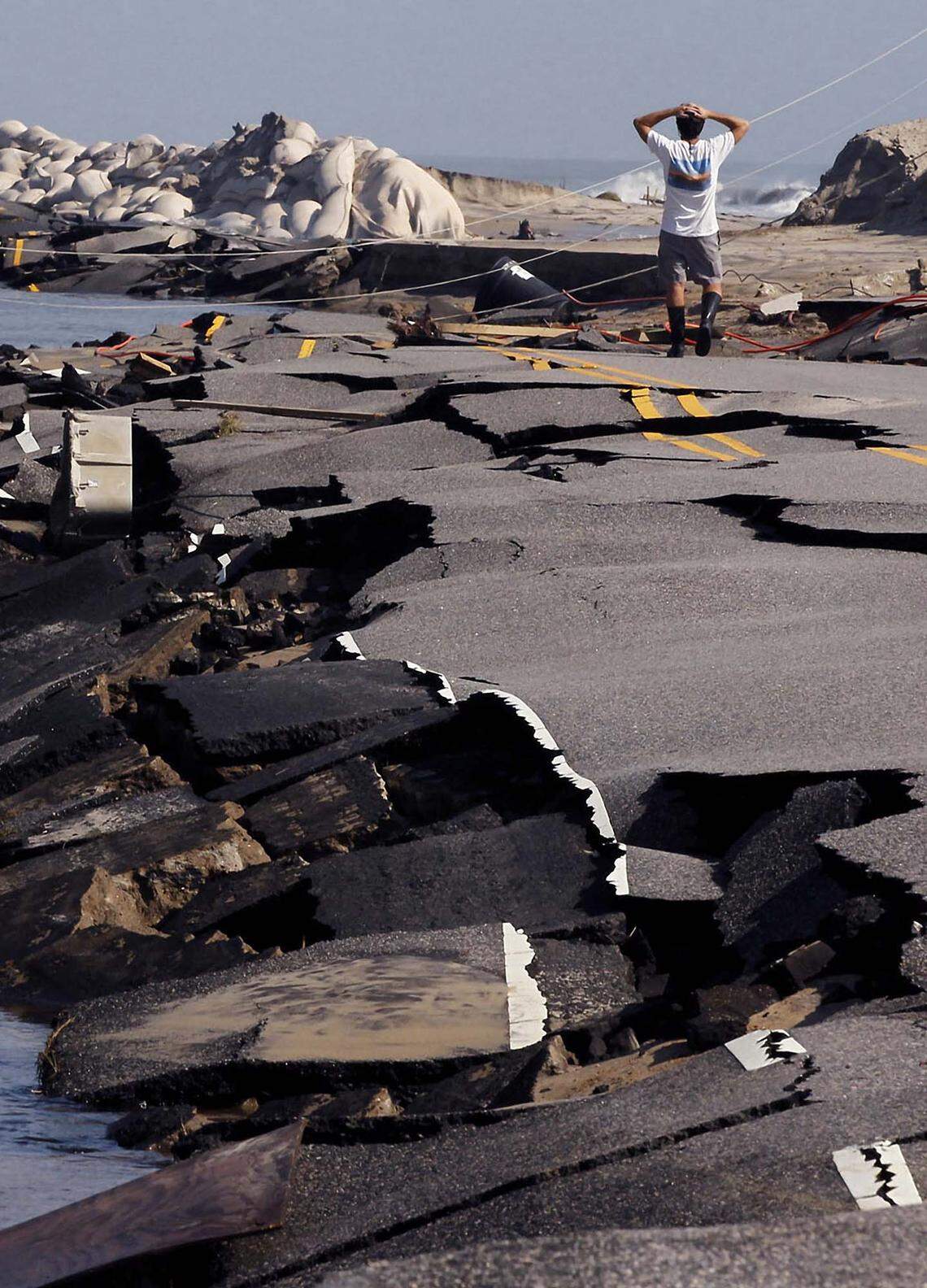 A man stares in disbelief at the destruction to N.C. Hwy 12 on the north edge of town, Sunday, Aug. 28, 2011 in Rodanthe, N.C.