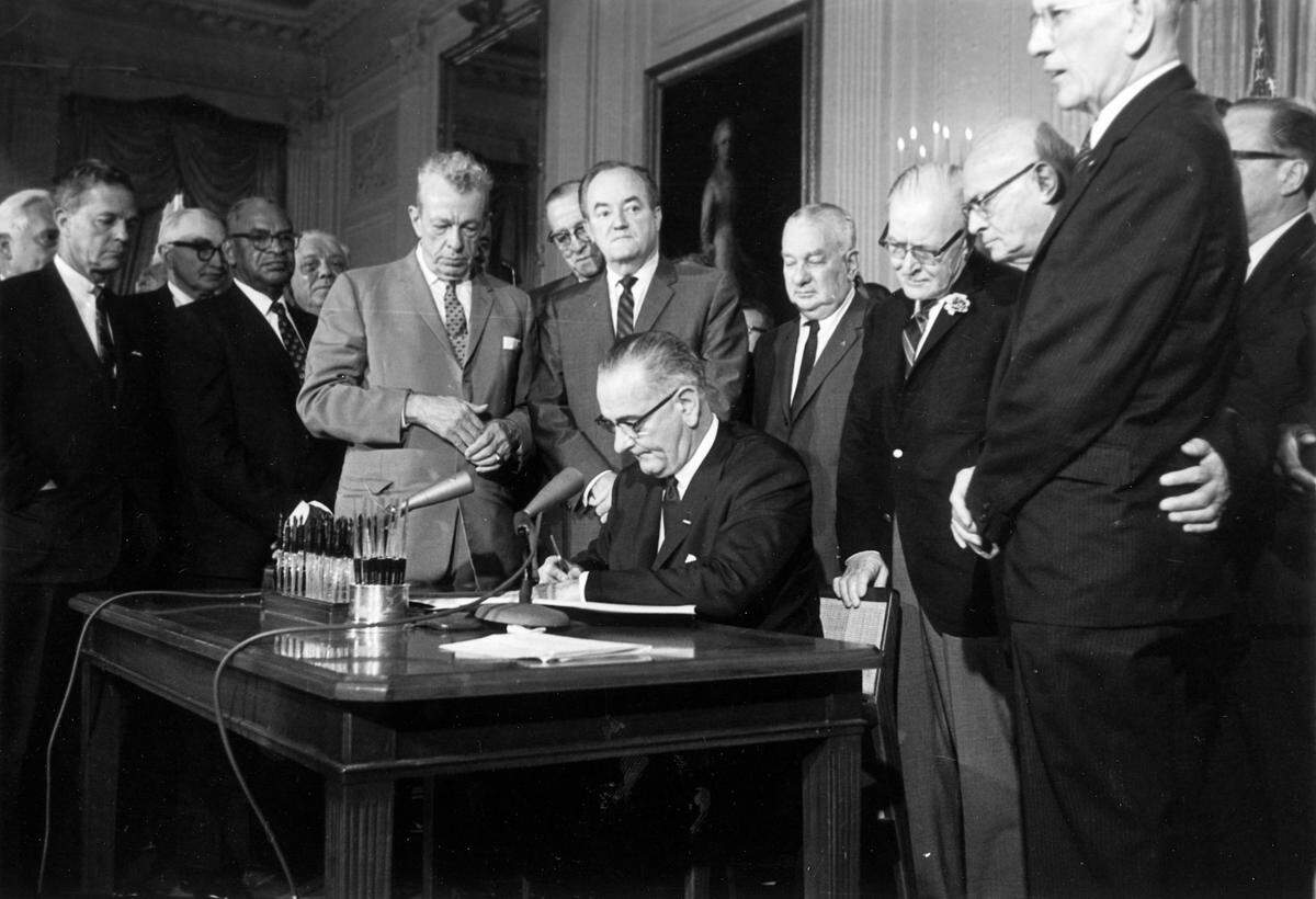 In this July 2, 1964 photo, President Lyndon Johnson signs the Civil Rights Act in the East Room of the White House in Washington. Standing from left, are Sen. Everett Dirksen, R-Ill.; Rep. Clarence Brown, R-Ohio; Sen. Hubert Humphrey, D-Minn.; Rep. Charles Halleck, R-Ind.; Rep. William McCullough, R-Ohio; and Rep. Emanuel Celler, D-N.Y.