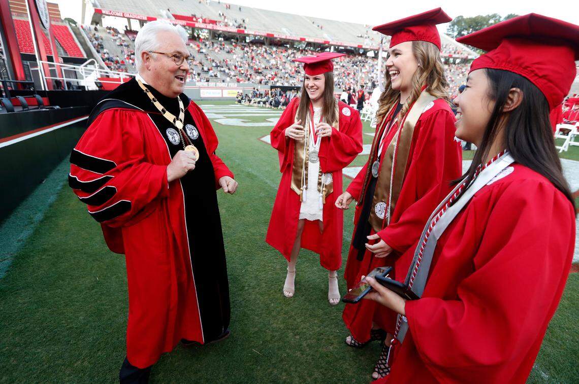 Chancellor Randy Woodson laughs with Kathryn Carter, center left, Kylee Redmond and Emma Langston, right, before N.C. State’s commencement ceremonies for the class of 2021 at Carter-Finley Stadium in Raleigh, N.C., Friday, May 14, 2021.
