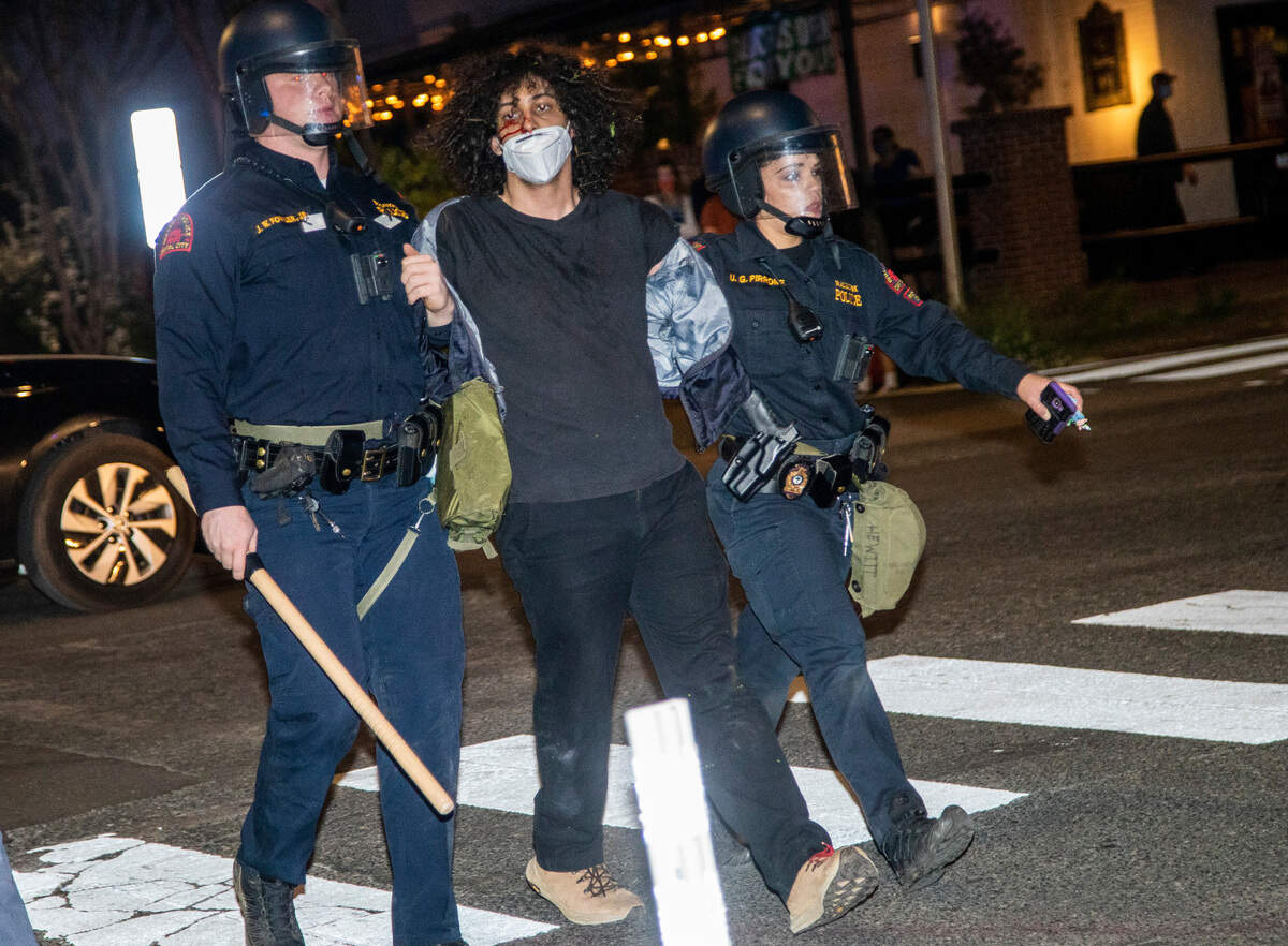 Police arrest a demonstrator during a march in downtown Raleigh following a vigil for Daunte Wright and others killed by police Sunday, April 18, 2021. At least 8 people were arrested.