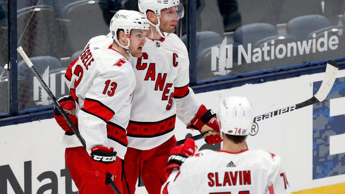 Carolina Hurricanes forwards Warren Foegele, left, and Jordan Staal and defenseman Jaccob Slavin celebrate Foegele’s goal against Columbus on Feb. 7, 2021. All three spent time this season on the NHL COVID-19 protocol list. (AP Photo/Paul Vernon)