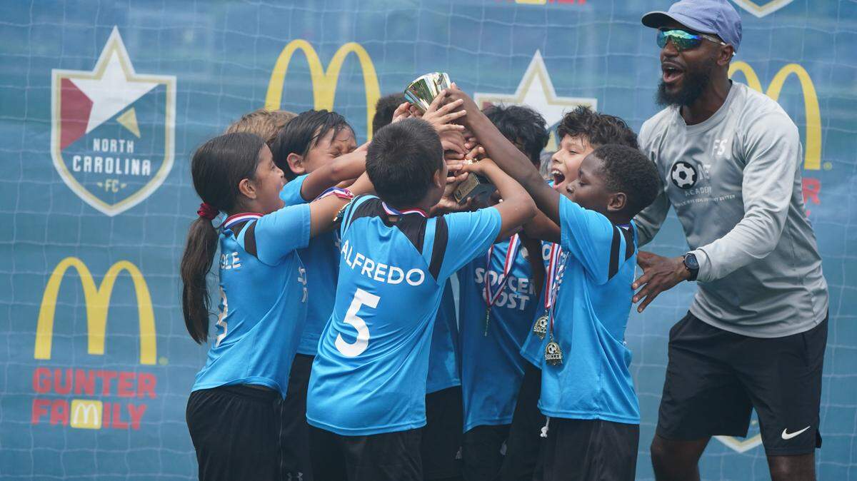 Young soccer players celebrate a championship win in the La Liga Del Sol soccer league.