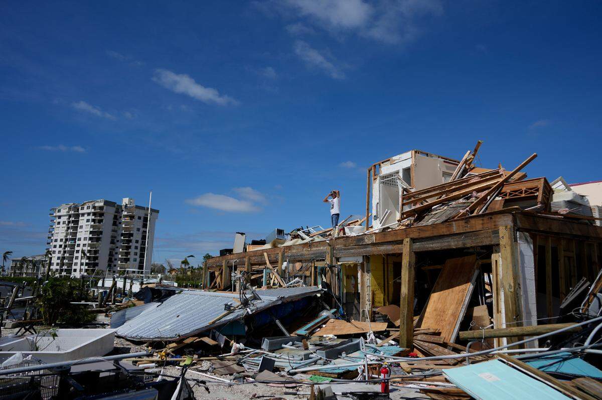Robert Leisure surveys the wreckage of his business, Getaway Marina, which was destroyed during the passage of Hurricane Ian, in Fort Myers Beach, Fla., Thursday, Sept. 29, 2022.
