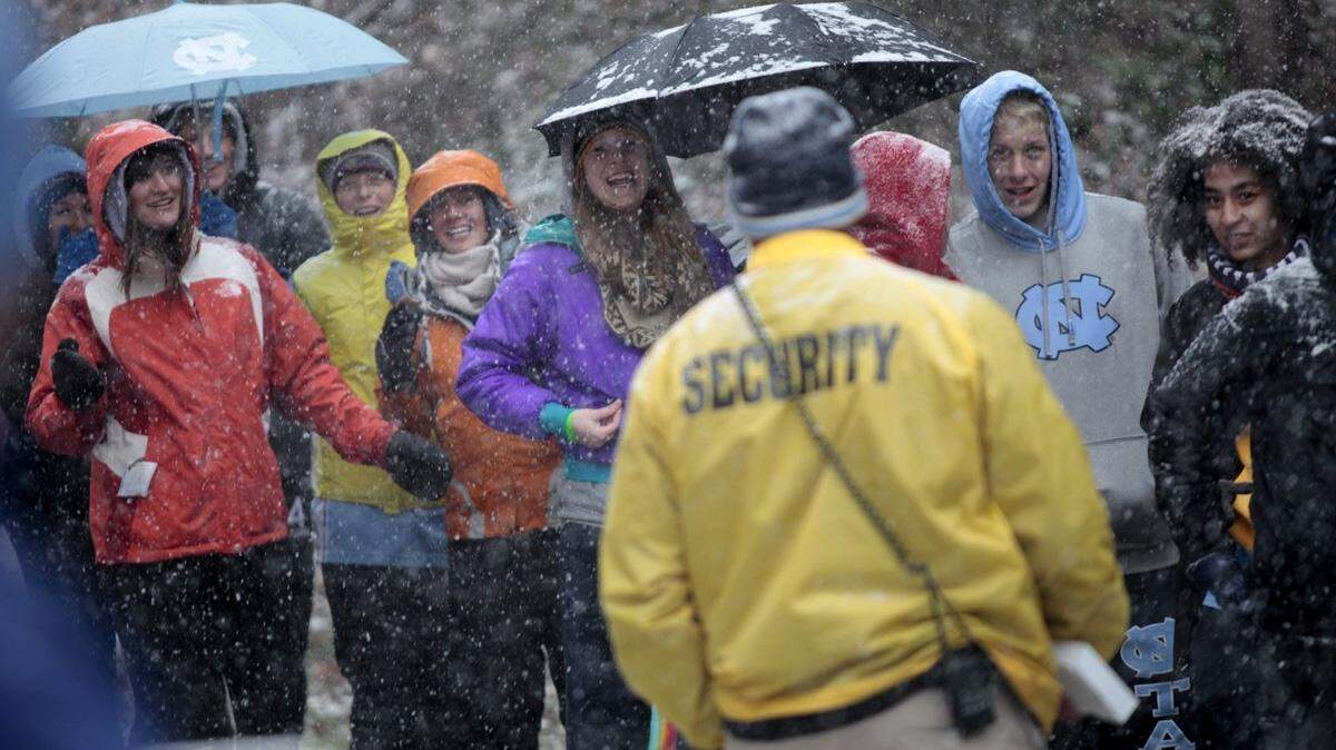 UNC students kept up their good spirits as the snow and winds picked up Wednesday, Feb. 12, 2014 outside of the Smith Center on the UNC campus as they waited in line for good seats to the UNC/Duke game.   The fast-moving snow and then ice storm Wednesday afternoon, however, forced a postponement of the game.