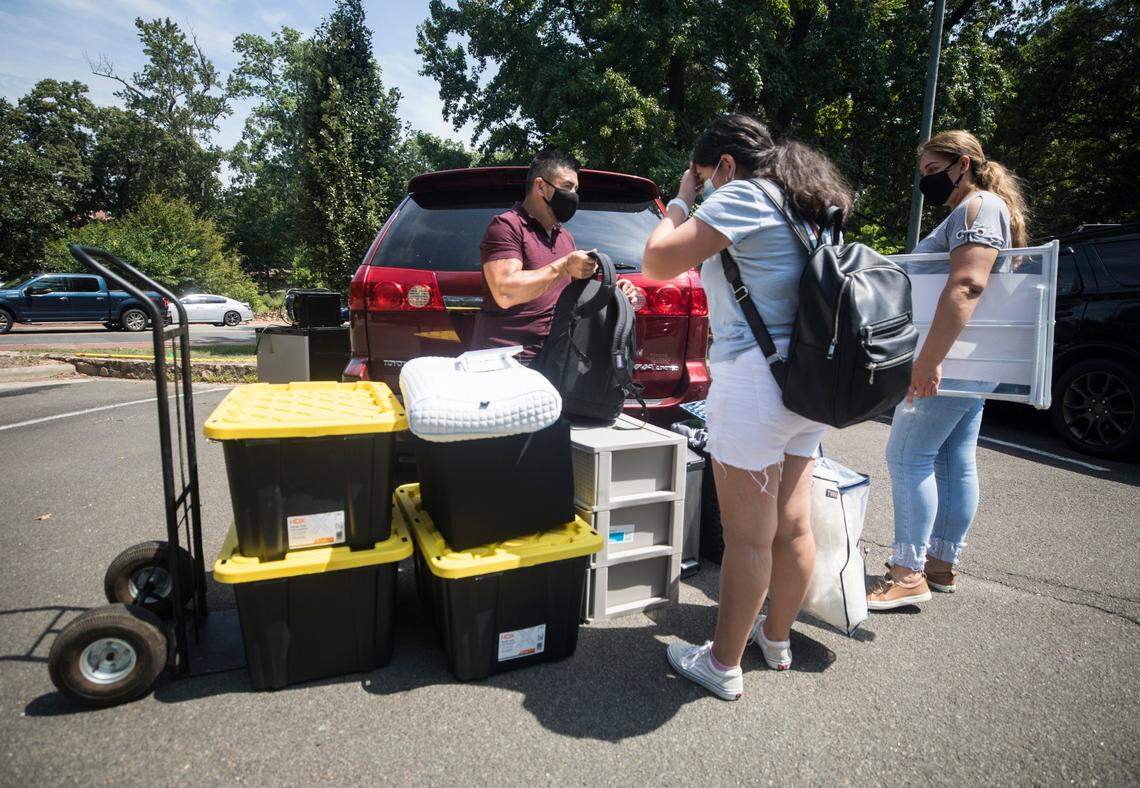 Victor Peralta, middle, hands items to his daughter Bridget, middle, and wife Dalia, right, as the family prepares to move Bridget into Residence Hall One on UNC-Chapel Hill’s campus for her first year of college on Thursday, Aug. 12, 2021.