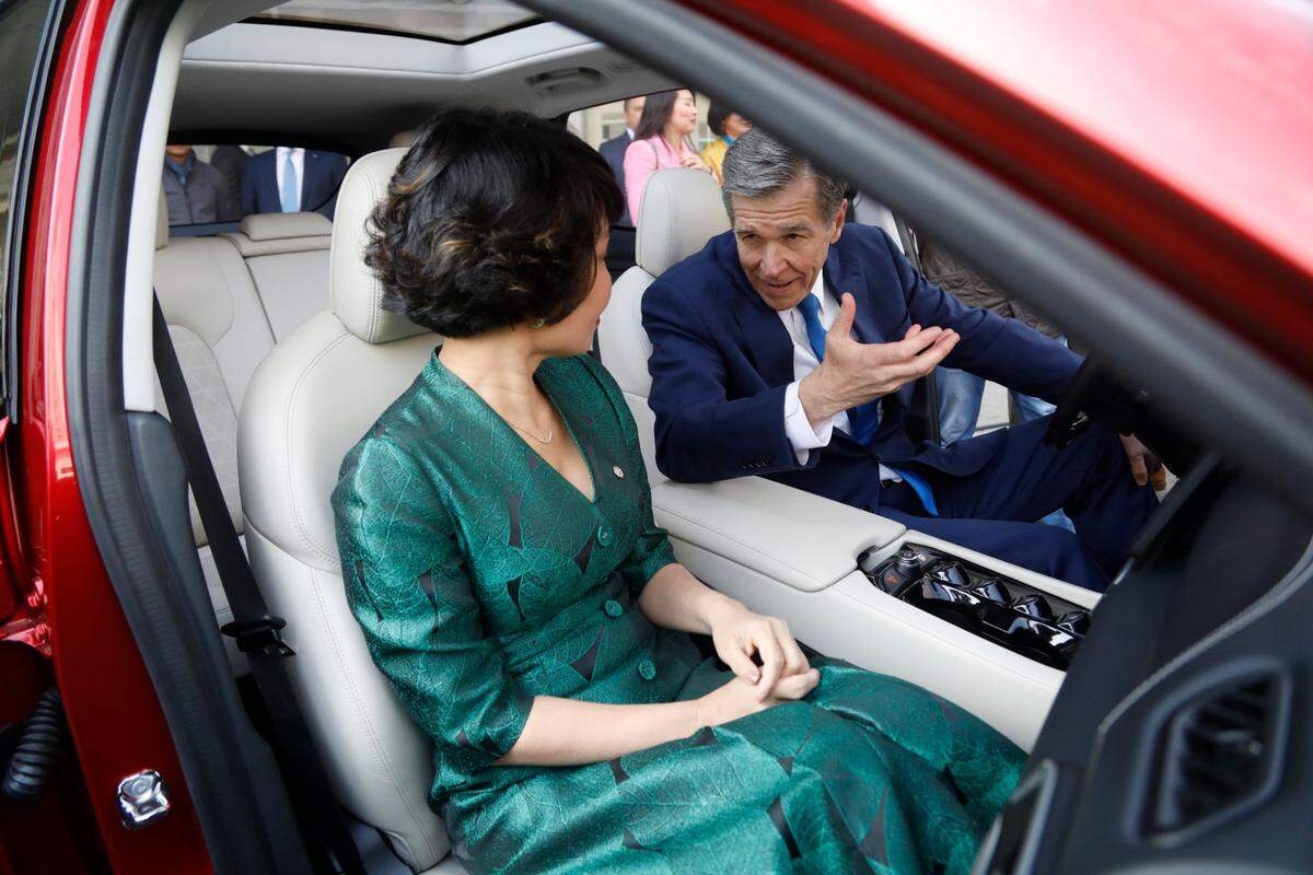 VinFast CEO Le Thi Thu Thuy and Gov. Roy Cooper sit inside a VF8 electric car Tuesday, March 29, 2022, outside the Raleigh Convention Center following an announcement that the company will build a manufacturing facility in Chatham County.