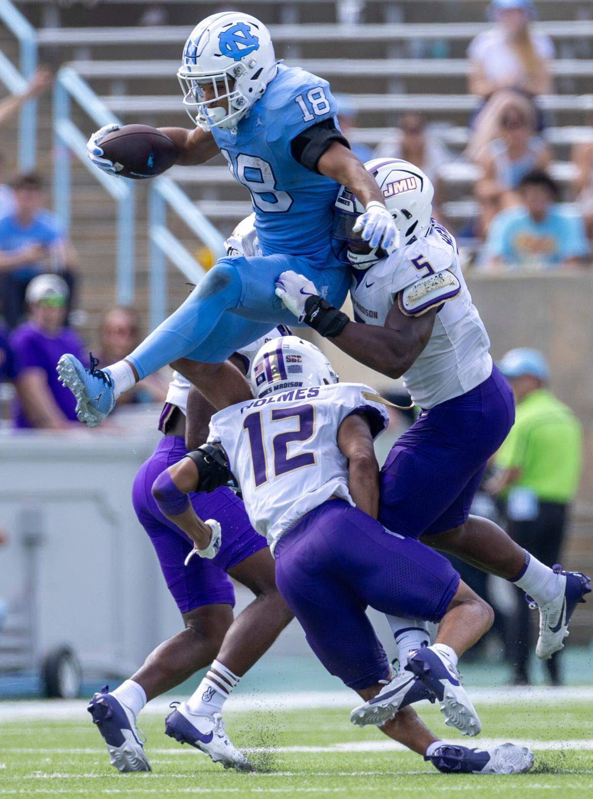 North Carolina tight end Bryson Nesbitt (18) hurdles over James Madison safety Kyle Holmes (12) after a 12-yard pass completion from quarterback Jacolby Criswell in the fourth quarter on Saturday, September 21, 2024 at Kenan Stadium in Chapel Hill, N.C.