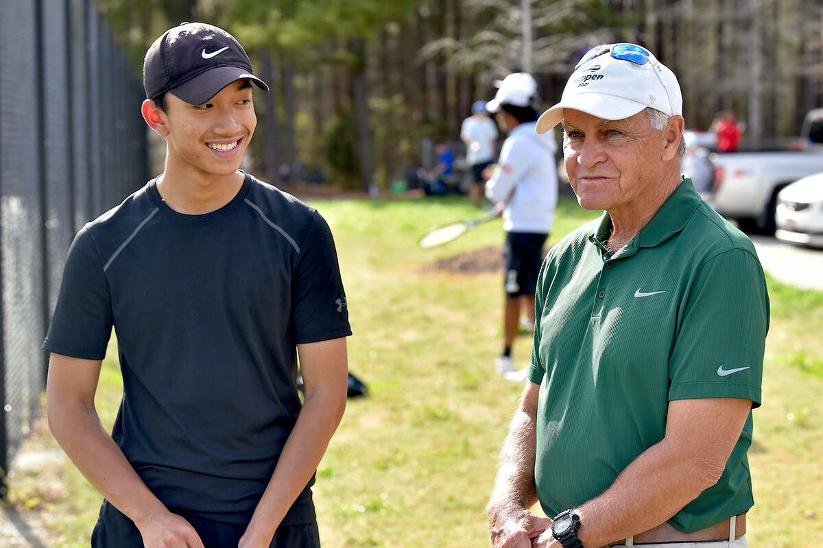 Enloe’s Andre Bautista, left, talks with head tennis coach Steve Spivey after his victory against Athens Drive. Enloe Tennis head Coach Steven Spivey gets his 1100th career victory with a win over Athens Drive High in Raleigh, N.C. on March 25, 2022.