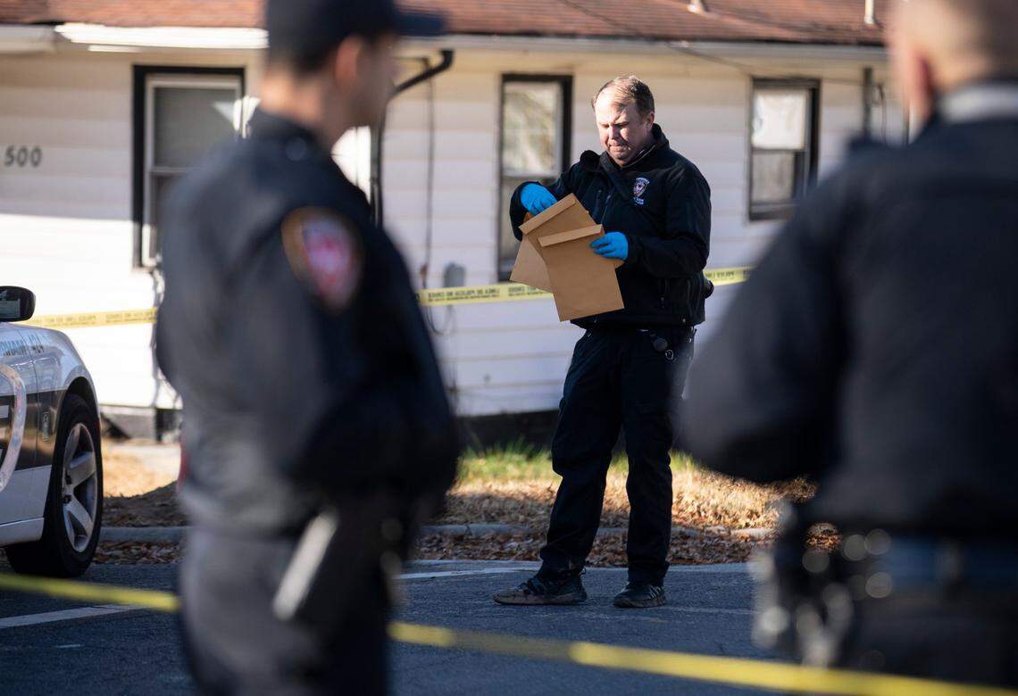A forensics investigator gathers evidence a block away from the scene of a shooting that killed two young people and injured four others in Durham, N.C. early Monday morning, Dec. 13, 2021.