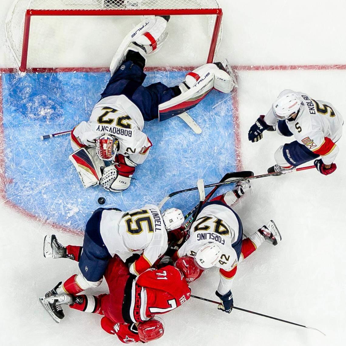 The Florida Panthers Anton Lundell (15) and Gustav Formling (42) smother the Carolina Hurricanes Jesper Fast (71) and Jesperi Kotkaniemi (82) with defense assisting goalie Sergei Bobrovsky (72) in the first overtime period during Game 1 of the Eastern Conference Finals on Friday, May 19, 2023 at PNC Arena in Raleigh, N.C.