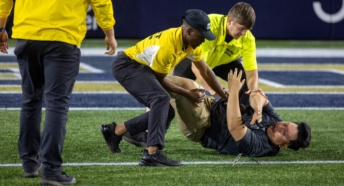 Security personnel tackle a Georgie Tech fan as they try to storm the field following the Yellow Jackets 46-42 victory over North Carolina on Saturday, October 28, 2023 at Bobby Dodd Stadium in Atlanta, Georgia.