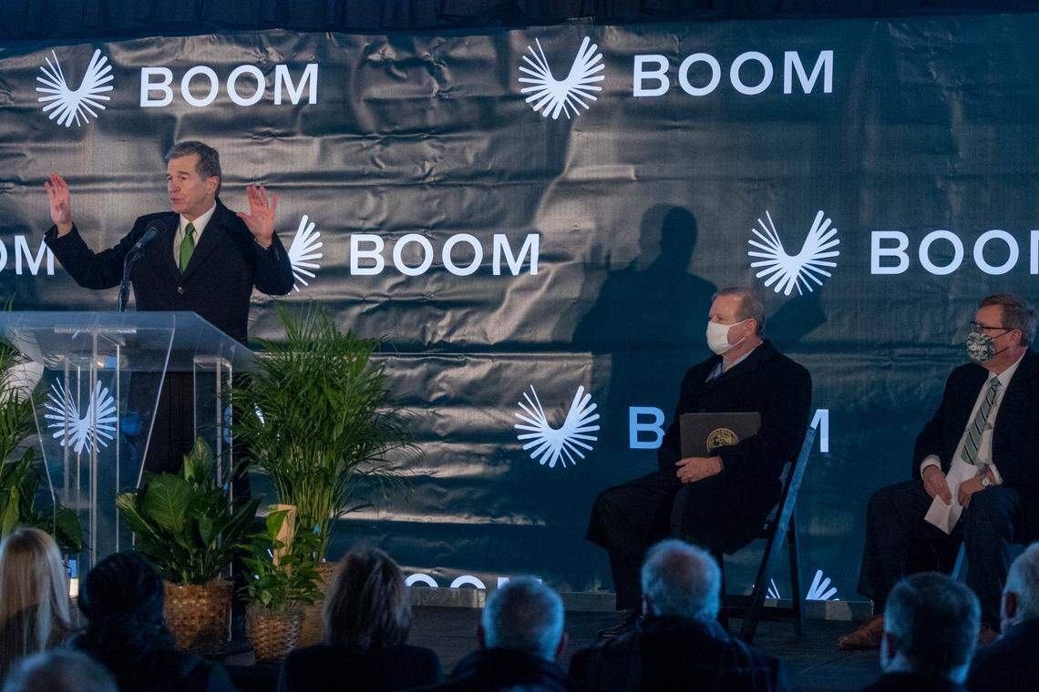 From left, Gov. Roy Cooper shares a stage with Senate President Pro Tempore Phil Berger and House Speaker Tim Moore during a press conference Wednesday, Jan. 26, 2022 at Greensboro’s Piedmont Triad International announcing Boom Supersonic’s plans to build a $500 million “flagship” production facility at the airport that is expected to create more than 1,750 jobs.